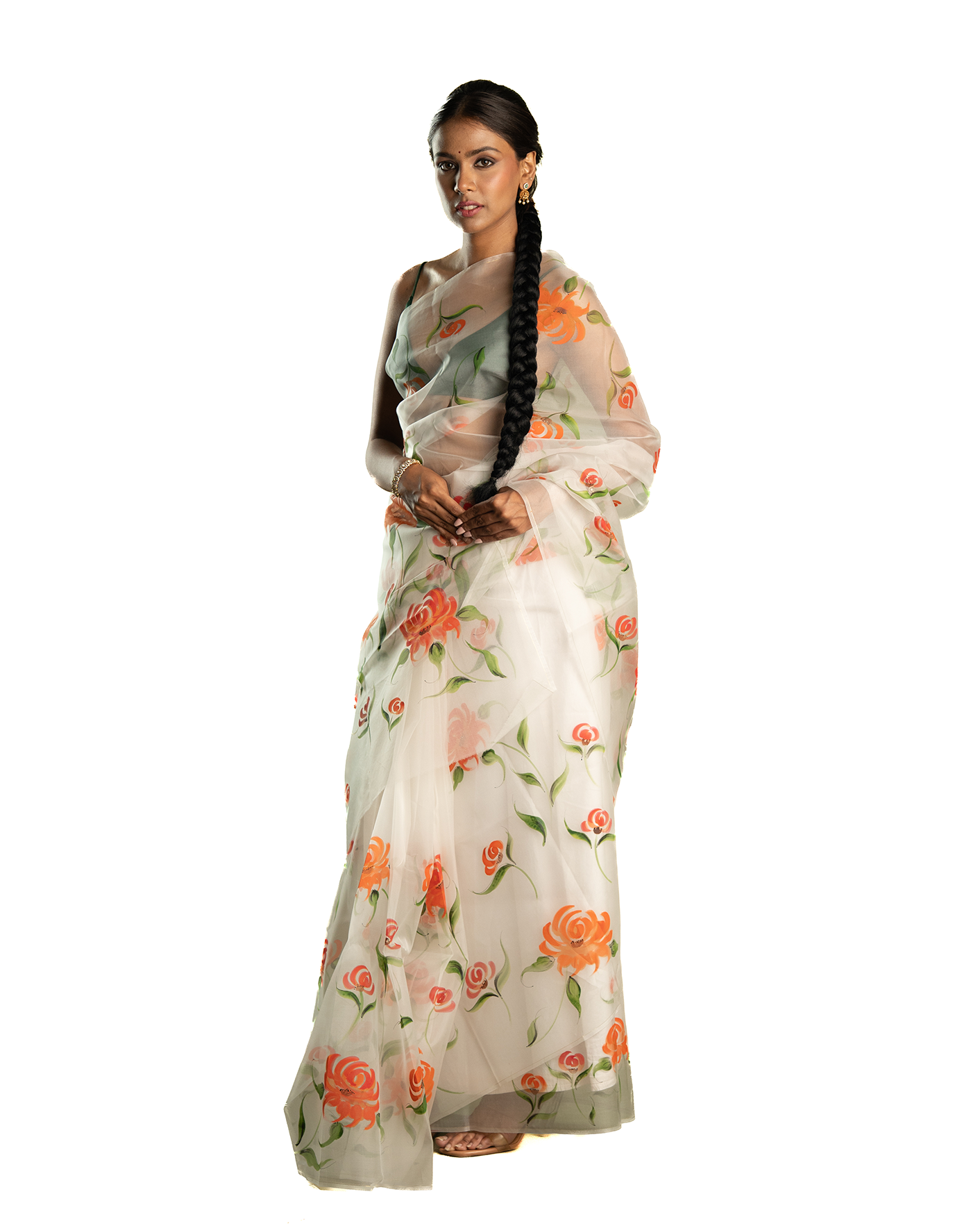 Woman wearing a floral orange saree on a white background