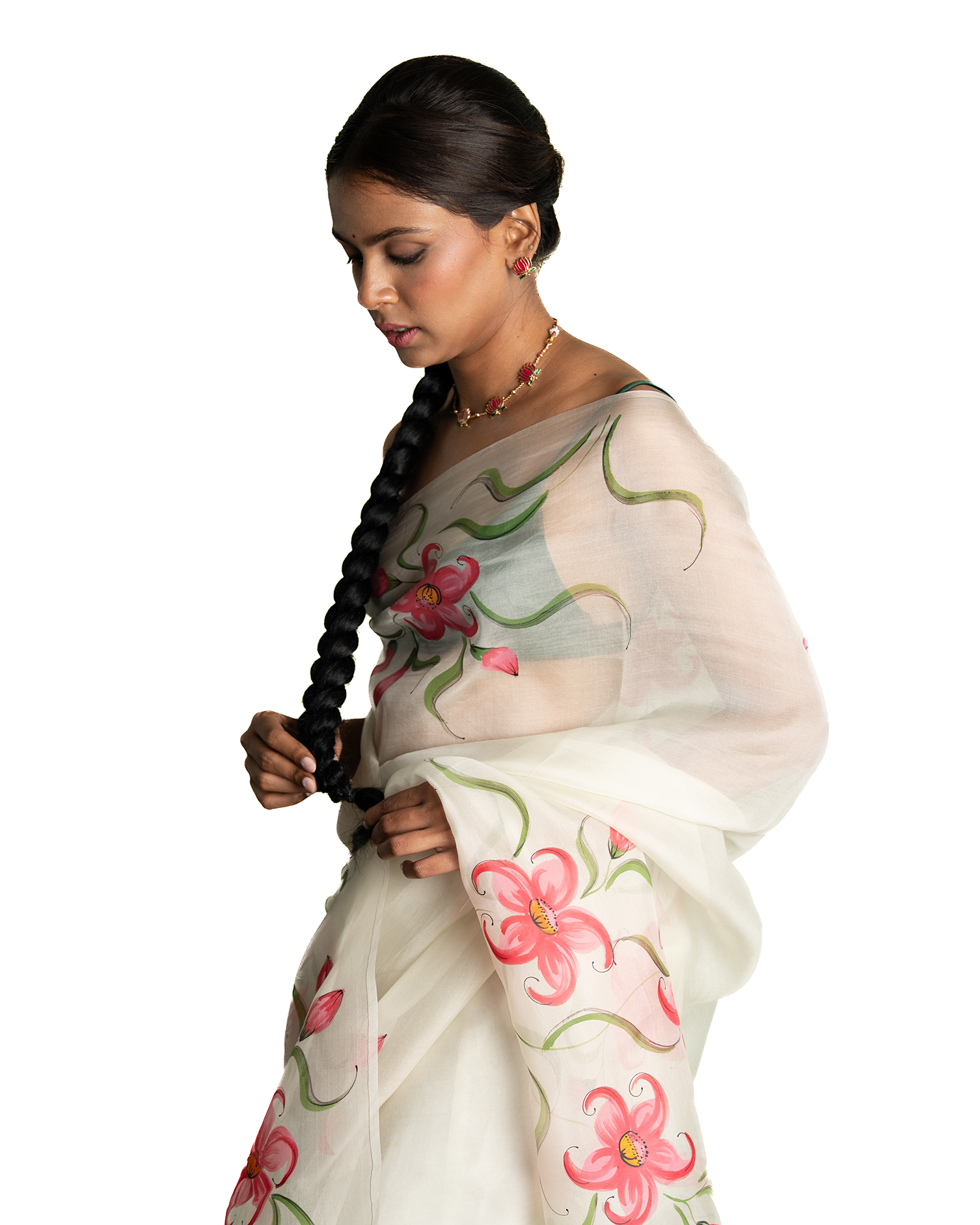 Woman wearing a white saree with floral patterns on a white background