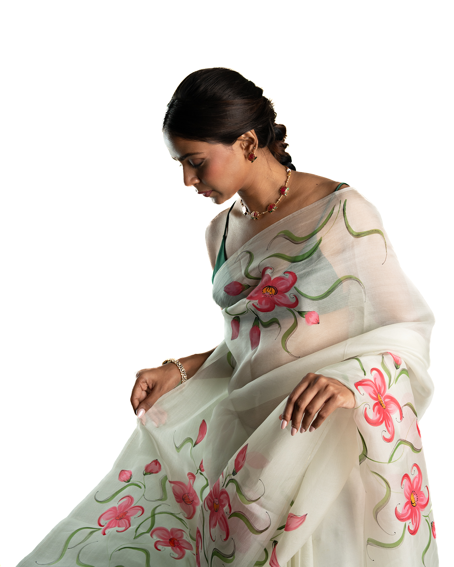 Woman wearing a white saree with floral patterns on a white background
