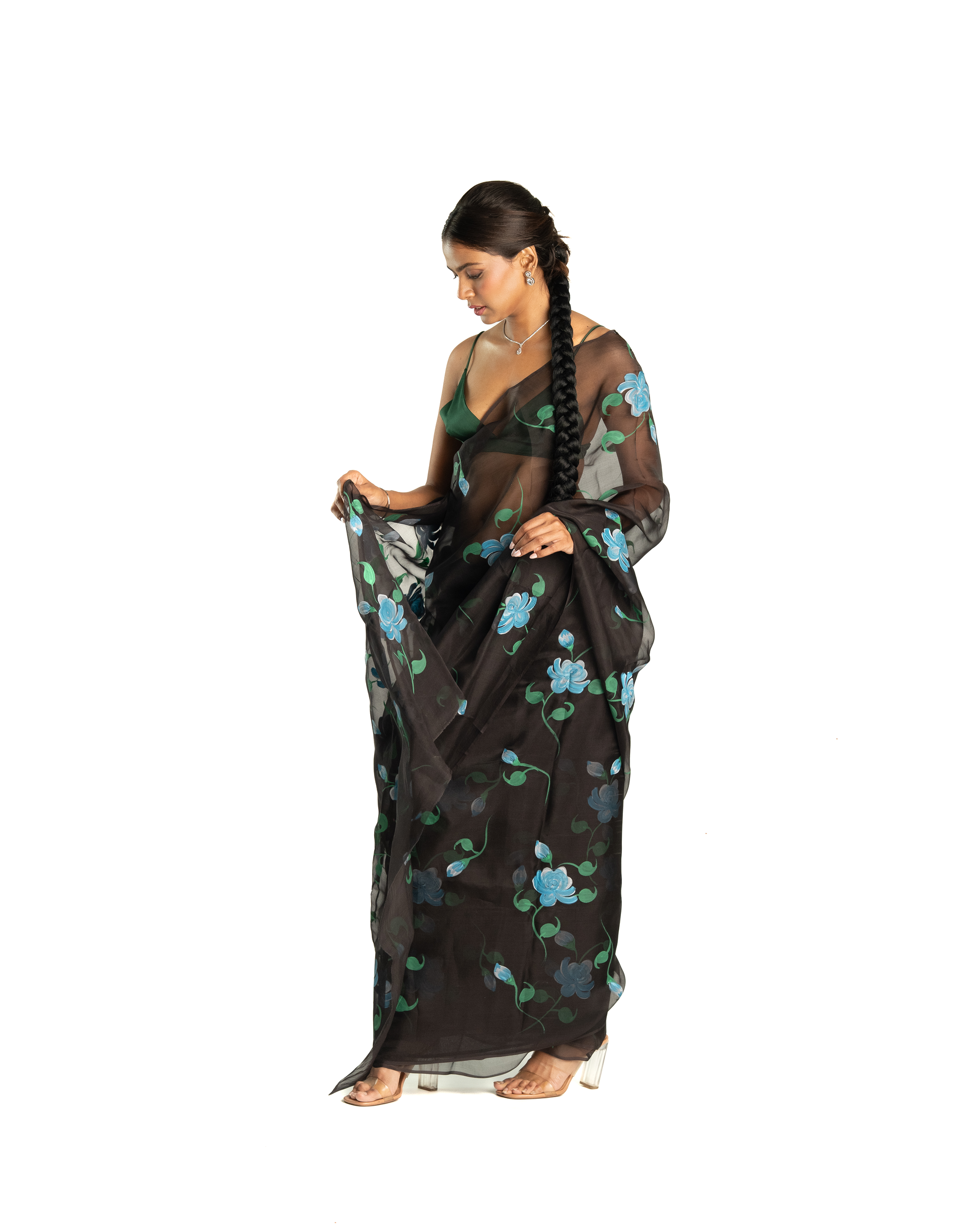 Woman wearing a black blue floral saree on a white background