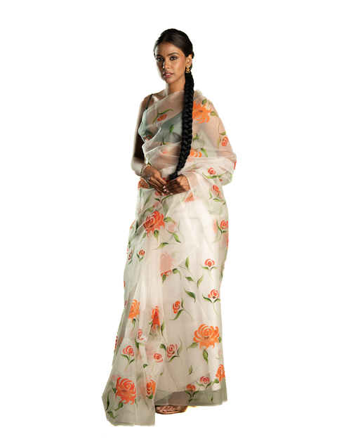 Woman wearing a floral orange saree on a white background