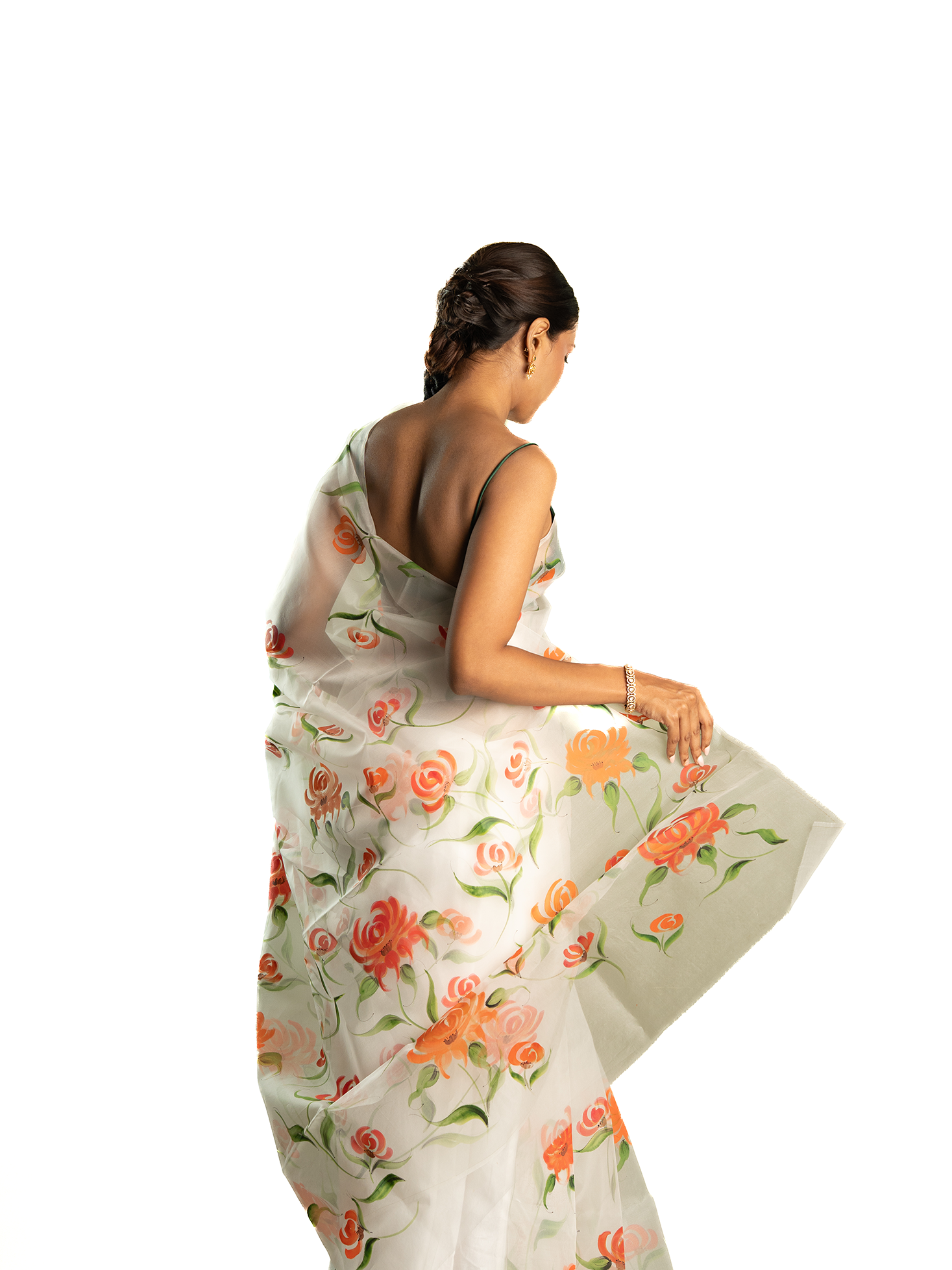 Woman wearing a orange floral saree on a white background
