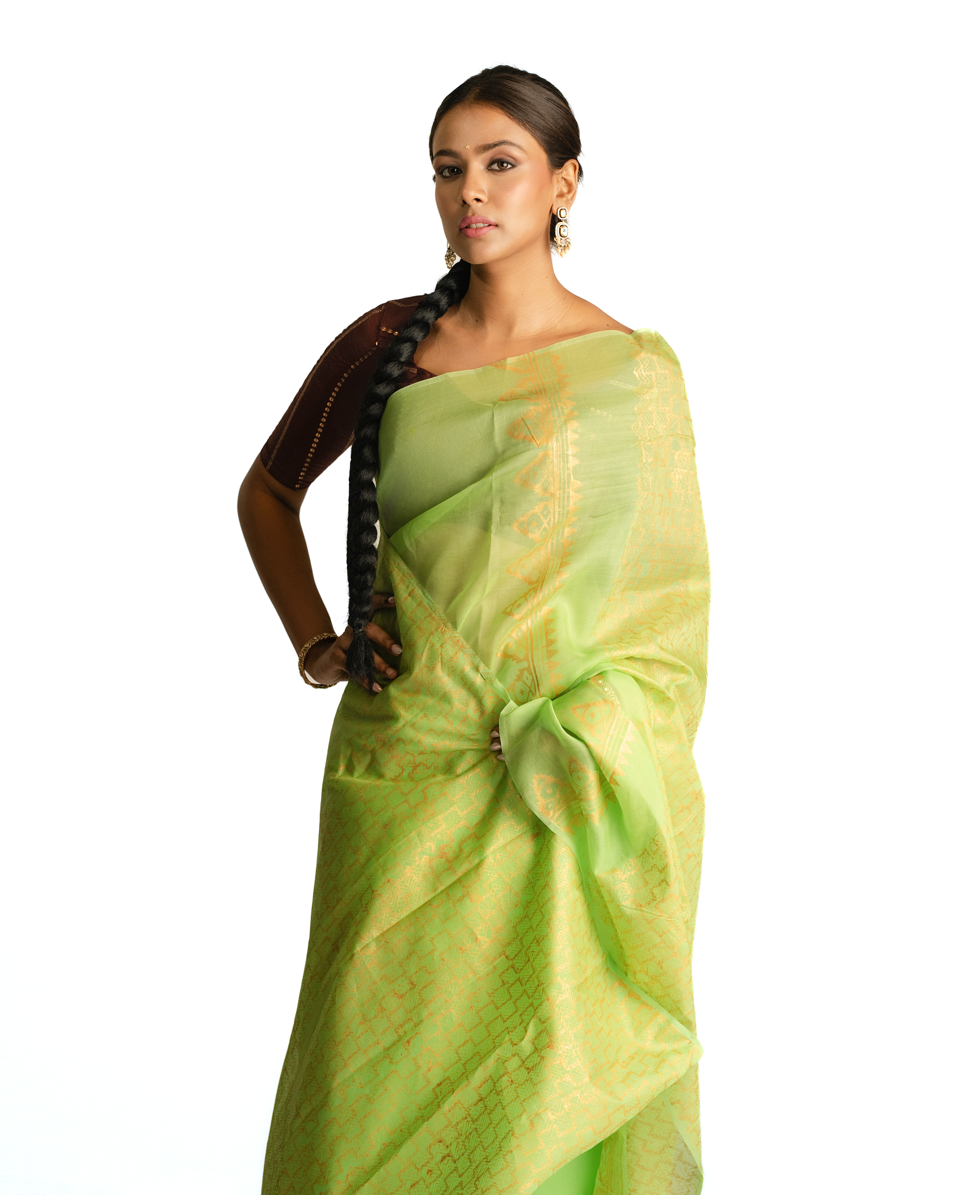 Woman wearing a light green saree with a white background