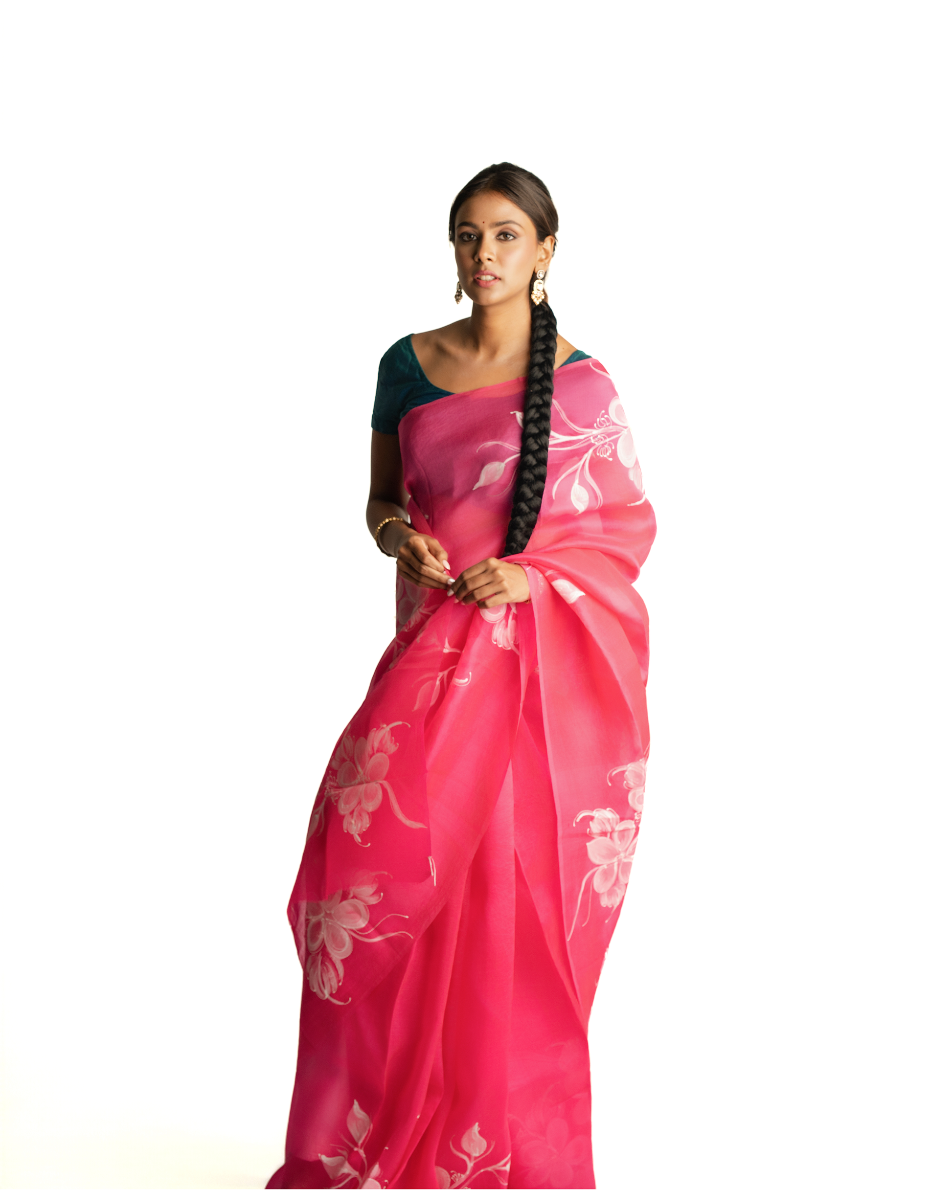 Woman wearing a pink saree with white floral patterns on a white background